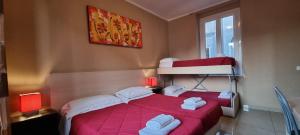 a bedroom with a red bed and a bunk bed at Hostel Mosaic in Rome