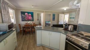 a kitchen with white cabinets and a stove top oven at Idle Days Beach House in Horseshoe Bay