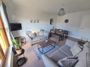 a living room with a couch and a table at Six Stevenson House, Oban in Oban