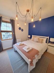 sypialnia z dużym łóżkiem z niebieską ścianą w obiekcie Six Stevenson House, Oban w mieście Oban