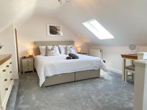 ein Schlafzimmer mit einem Bett und einem Dachfenster in der Unterkunft Modern 4-bed Cottage Llanwrst Town Centre & Parking - Snowdonia! near Betws-y-Coed in Llanrwst