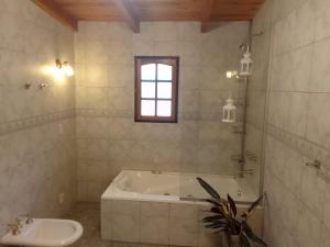 y baño con bañera y lavamanos. en Casa Curapil en San Carlos de Bariloche