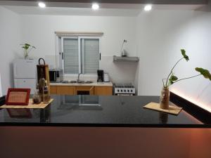 a kitchen with a table with two vases on it at Arco-yris in Ponta do Sol