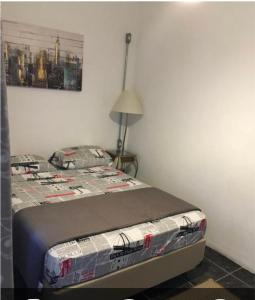 a bedroom with a bed and a lamp in a room at Augusta Jardins Home in Sao Paulo