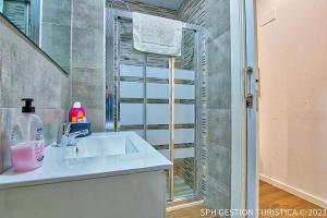 a bathroom with a sink and a shower with a window at Acogedor Loft Centro Murcia in Murcia