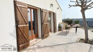 un par de puertas de madera en el lateral de un edificio en Casa Rural Mas de les Àligues, en Mequinenza