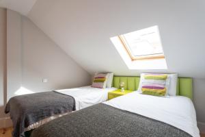 two beds in a attic room with a skylight at Santa Justa 24 Lisbon Downtown in Lisbon