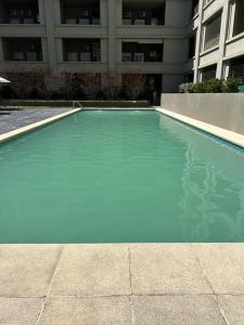 a blue swimming pool in front of a building at Apartamento céntrico in Montevideo