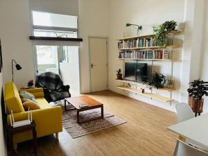 un soggiorno con divano giallo e tavolo di Apartamento céntrico a Montevideo