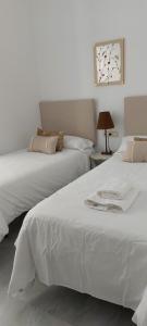 two beds sitting next to each other in a bedroom at el 2 de Flamenco 2ºA in Cádiz