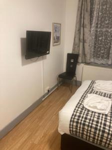 1 dormitorio con 1 cama y TV de pantalla plana en 3 Bed Sea View Apartment @ 10B George Street en Ryde