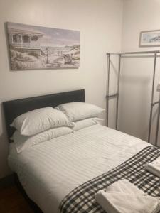1 cama en un dormitorio con una foto en la pared en 3 Bed Sea View Apartment @ 10B George Street en Ryde