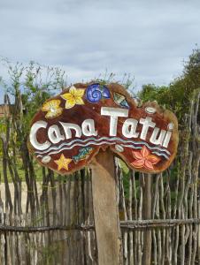a sign in front of a wooden fence at Casa Tatuí in Pôrto de Pedras