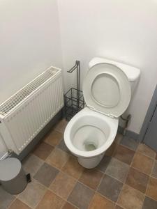 a bathroom with a white toilet and a tile floor at 3 Bed Sea View Apartment @ 10B George Street in Ryde