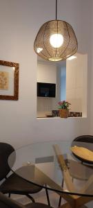 a dining room with a glass table and a light fixture at el 2 de Flamenco 2ºA in Cádiz
