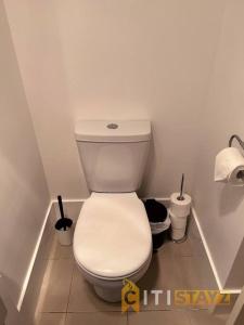 un aseo blanco en un baño con 2 rollos de papel higiénico en Relaxing Oasis in Bruce -1bd 1bth 1 carsp Apt en Belconnen