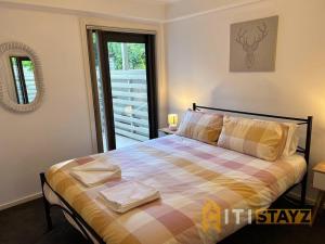 a bedroom with a bed with a checkered blanket at Relaxing Oasis in Bruce -1bd 1bth 1 carsp Apt in Belconnen