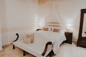 Los Murmullos Casa Boutique por chef Patrick Cros, Campeche في كامبيش: غرفة نوم بيضاء بسرير ابيض ومقعد +27 صورة