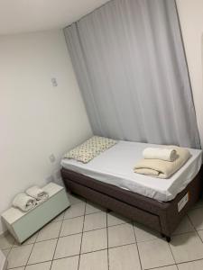 a small bedroom with a bed with a canopy at A dois passos do mar… in Vila Velha