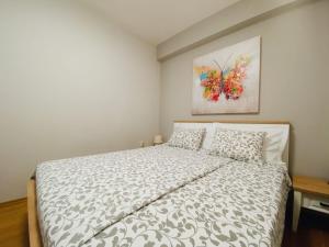 a bedroom with a bed and a painting on the wall at Family friendly apartments with a swimming pool Povljana, Pag - 244 in Povljana