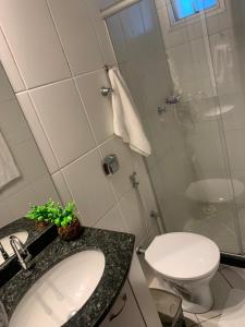 a bathroom with a toilet and a sink and a shower at A dois passos do mar… in Vila Velha