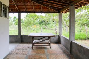 a picnic table on a porch with a view of a field at Rancho Boa Vista in Barreirinhas