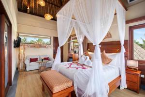 a bedroom with a bed with white drapes at Ubud Nyuh Bali Resort & Spa - CHSE Certified in Ubud
