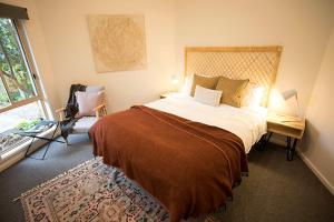 a bedroom with a large bed and a window at MONREPOS in Point Lonsdale