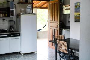 バヘイリーニャスにあるRancho Boa Vistaのキッチン(冷蔵庫、テーブル、椅子付)