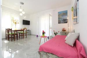 a bedroom with a pink bed and a dining room at Apartments for families with children Novalja, Pag - 6490 in Novalja