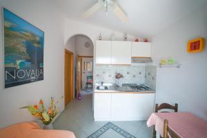 a kitchen with white cabinets and a table at Apartments for families with children Novalja, Pag - 6490 in Novalja