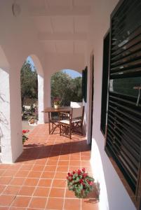 un patio al aire libre con una mesa y flores. en Vinya Alice, en Ciutadella