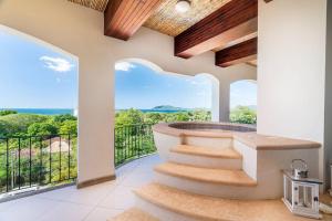 uma casa com uma varanda e uma banheira de hidromassagem em Ocean View Penthouse In Tamarindo w/ BeachClub Access em Tamarindo