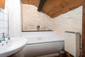 a bathroom with a white tub and a sink and a sink at Glan Lledr in Betws-y-coed +25 photos