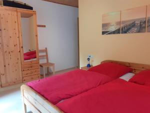 una camera da letto con un grande letto con lenzuola rosse di Ferienhaus für 6 Personen ca 96 qm in Großbreitenbach, Thüringen Rennsteig a Großbreitenbach