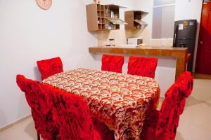una mesa con sillas rojas en una habitación en SUNRISE home, en Ica