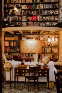 Los Murmullos Casa Boutique por chef Patrick Cros, Campeche في كامبيش: غرفة مع طاولة وكراسي ورف كتاب