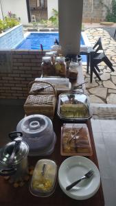 einen Tisch mit Tabletts mit Lebensmitteln auf einem Tisch in der Unterkunft Mangabeiras - Casa de Hóspedes in Alto Paraíso de Goiás