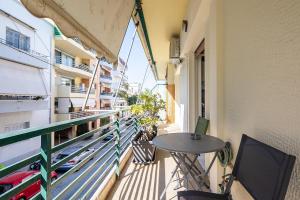 balkon ze stołem i krzesłami na budynku w obiekcie Olympic Mets Apartment w Atenach