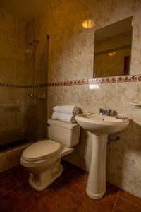 La salle de bains est pourvue de toilettes, d'un lavabo et d'une douche. dans l'établissement Hotel Rivera, à Ayacucho