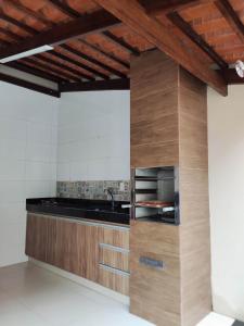 a kitchen with wooden cabinets and a counter top at Casa temporada AURORA in São João Batista do Glória