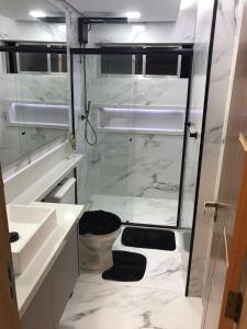a bathroom with a shower and a sink and a toilet at Apto aconchegante vista mar , tv, wifi e ar - Praia São Vicente in São Vicente