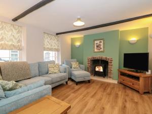 a living room with a couch and a fireplace at Granary Cottage in Warminster