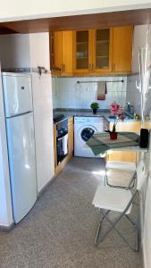 a kitchen with a table and a white refrigerator at Lisbon Airport Guesthouse in Lisbon