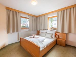 um quarto com uma cama e duas janelas em Beautiful Apartment in L ngenfeld with Terrace em Längenfeld
