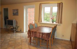 a dining room with a table and chairs and a television at Holiday Home Vadgårdsvej in Nørre Nebel