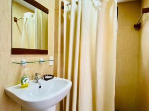 a bathroom with a sink and a shower curtain at Casa Cecilia in El Nido