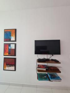 Une télévision avec des photos est installée au-dessus d'un mur. dans l'établissement Hermoso apartamento de lujo en Morros 3 , Piso 5 con vista al mar, à Carthagène des Indes