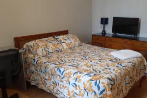 1 dormitorio con 1 cama y TV de pantalla plana en Hospedaje Kelita, en Moquegua