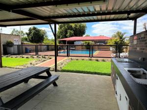 um pátio com uma mesa de piquenique e comodidades para churrascos em Banksia Tourist Park em Perth